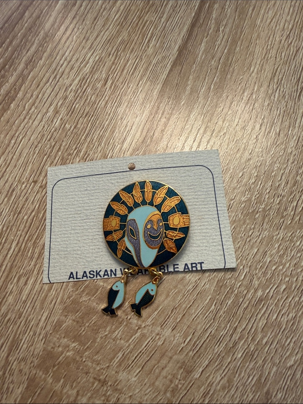 Alaskan Adornments Teal & Gold Sun Mask Pin with Fish Charm
